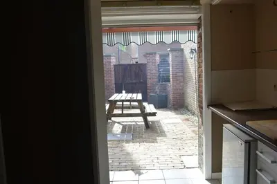 an open door to a patio with a picnic table at Vakantiewoning Bij de Jep in Bilzen