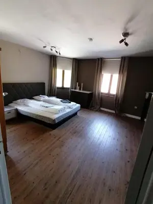 a large bedroom with a bed and a wooden floor at Vakantiewoning Bij de Jep in Bilzen