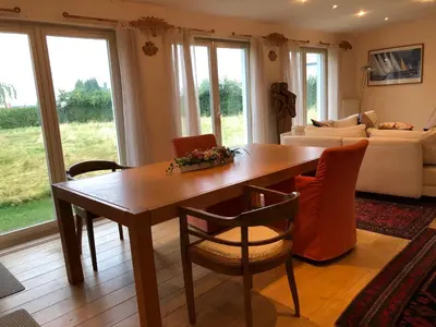 a living room with a wooden table and chairs at Landhaus Sylvia in Eupen, Terrasse , Garten & Nähe zum Hohen Venn in Eupen