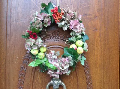 a wreath on a door with apples and flowers at Landhaus Sylvia in Eupen, Terrasse , Garten & Nähe zum Hohen Venn in Eupen