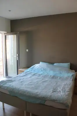 a large bed in a bedroom with a window at Logie Rotem in Dilsen-Stokkem