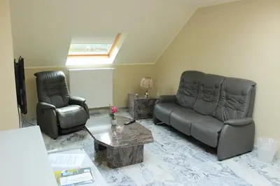 a living room with a couch and a chair at B&B Don Genaro in Dilsen-Stokkem