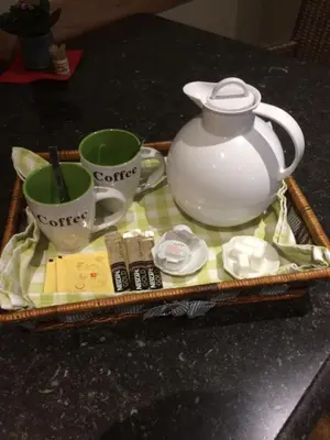 a tray with two cups and a tea pot on a table at B&B Don Genaro in Dilsen-Stokkem