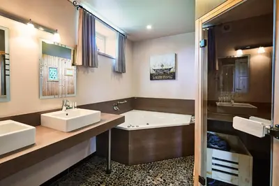 a bathroom with two sinks and a bath tub at Wellness B&B De Zevenslaper in Geetbets