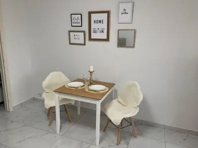 a dining room table with two chairs and a table with plates on it at Le Cocon d'Avroy in Liège