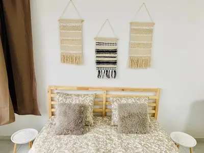 a bedroom with a bed with pillows and hanging garments at Le Cocon d'Avroy in Liège
