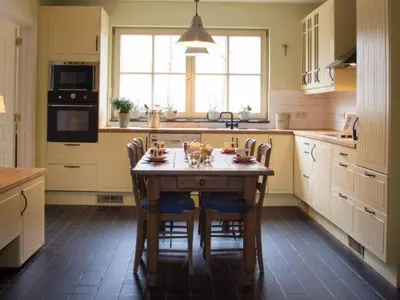 a kitchen with a wooden table and chairs in it at 'Hof der Heerlijckheid' in Borgloon