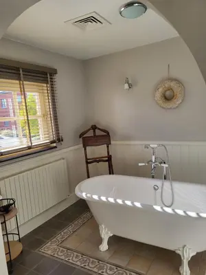 a white bath tub in a bathroom with a window at 'Hof der Heerlijckheid' in Borgloon