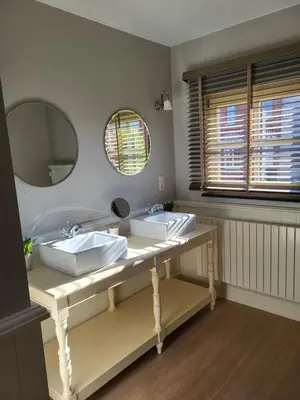 a bathroom with two sinks and a large mirror at 'Hof der Heerlijckheid' in Borgloon