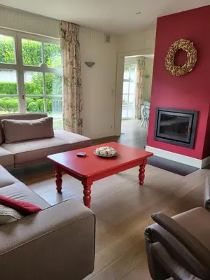 a living room with a red wall and a red coffee table at 'Hof der Heerlijckheid' in Borgloon
