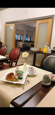 a table with a plate of food and a flower on it at Belrom Hotel in Sint-Truiden
