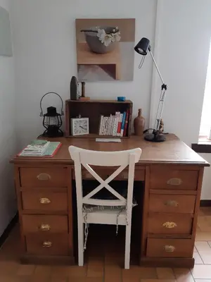 a desk with a white chair and a lamp at La Pause in Plombières