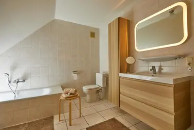 a bathroom with a tub and a sink and a toilet at Le fond d'Or in Borgloon
