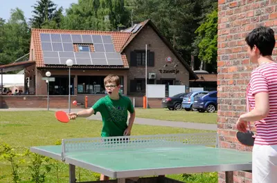 a young man holding a frisbee on a ping pong table at Vakantiewoning Zavelbos in Maaseik