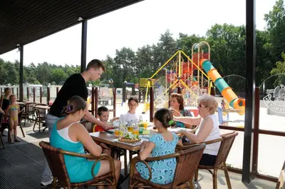 a group of people sitting at a table at a playground at Vakantiewoning Zavelbos in Maaseik
