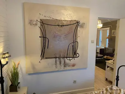 a painting hanging on a wall in a living room at Chalet Sint Barbara in Zutendaal