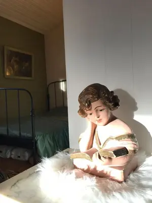 a statue of a woman sitting on a bed at Chalet Sint Barbara in Zutendaal