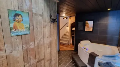 a bathroom with a toilet and a painting on the wall at Een vleugje wellness in de Voerstreek - Bed & Brocante Onder de Poort in Voeren
