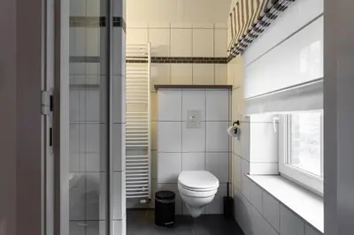 a bathroom with a toilet and a window at B&B De Floreffe in Overpelt