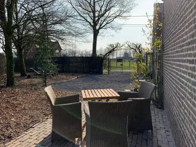 a patio with a table and chairs and a fence at B&B Dageraad in Bocholt