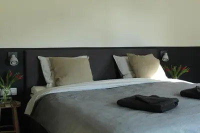 a large bed with a black headboard and white pillows at B&B Dageraad in Bocholt
