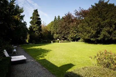 a park with a bench in the middle of a field at B&B Het Agnetenklooster in Maaseik
