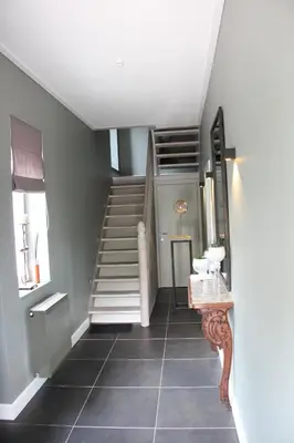a hallway with a staircase and a tiled floor at AMADIS in Kesselt