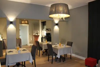 a dining room with tables and chairs and a chandelier at AMADIS in Kesselt