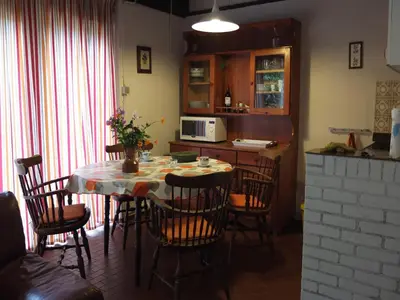 a kitchen with a table with chairs and a microwave at Holiday Home in Gemmenich with Forest Views in Ten Eiken