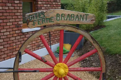 a wooden sign sitting on top of a wooden wheel at Holiday home La ferme brabant in Voeren