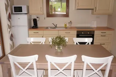 a kitchen with a wooden table and white chairs at Holiday home La ferme brabant in Voeren