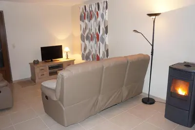 a living room with a couch and a fireplace at Holiday home La ferme brabant in Voeren
