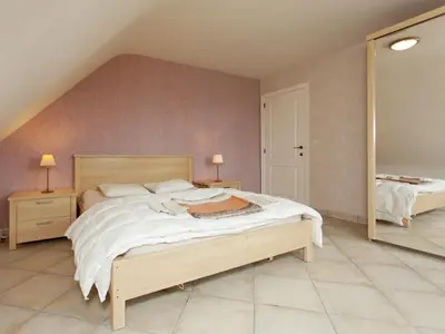 a bedroom with a large bed and two mirrors at Peer Villa with Garden in Peer