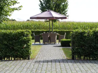a table and chairs under an umbrella on a patio at Peer Villa with Garden in Peer