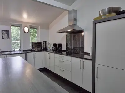 a kitchen with white cabinets and a stainless steel counter top at Monastery Retreat in Blossoming Limburg in Sint-Truiden