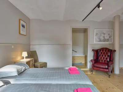 a bedroom with a bed and a red chair at Monastery Retreat in Blossoming Limburg in Sint-Truiden