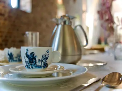 a cup and saucer on a table with a tea kettle at Monastery Retreat in Blossoming Limburg in Sint-Truiden