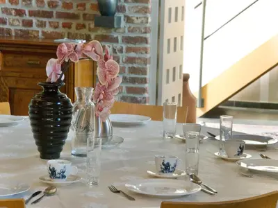 a table with a vase with flowers on it at Monastery Retreat in Blossoming Limburg in Sint-Truiden