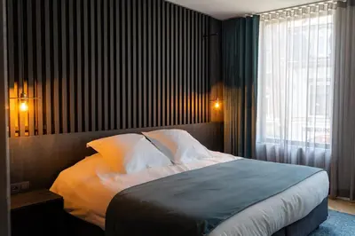 a bedroom with a large bed and a window at Designhotel Beila in Bilzen