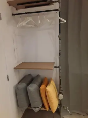 a closet with a gray couch and yellow pillows at Hébergement Les Heros in Liège