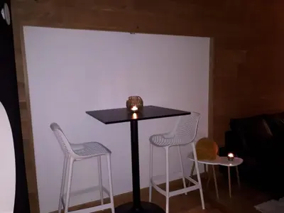 a table and two stools in a room at Hébergement Les Heros in Liège