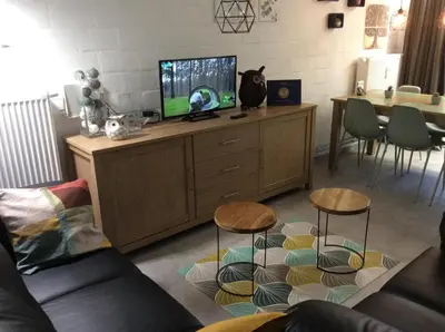 a living room with a tv on a cabinet with stools at Acacia 1 Hengelhoef in Houthalen-Helchteren