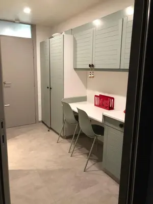 a kitchen with white cabinets and a table and chairs at Acacia 1 Hengelhoef in Houthalen-Helchteren