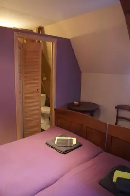 a bedroom with a purple bed with a mirror at B&B De Metstermolen in Sint-Truiden