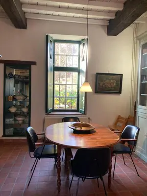 a dining room with a wooden table and chairs at B&B De Metstermolen in Sint-Truiden