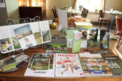 a table with magazines and brochures on it at B&B De Vroling in Wellen
