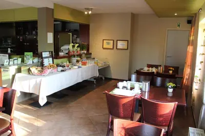 a restaurant with a table and chairs and a counter at B&B De Vroling in Wellen