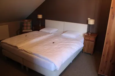 a bedroom with a large white bed with two pillows at B&B De Vroling in Wellen