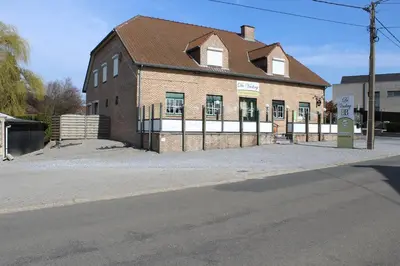 an old brick building with a gate on a street at B&B De Vroling in Wellen