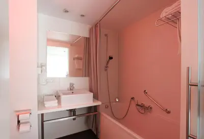 a bathroom with a sink and a shower at Hotel De Pits in Heusden - Zolder
